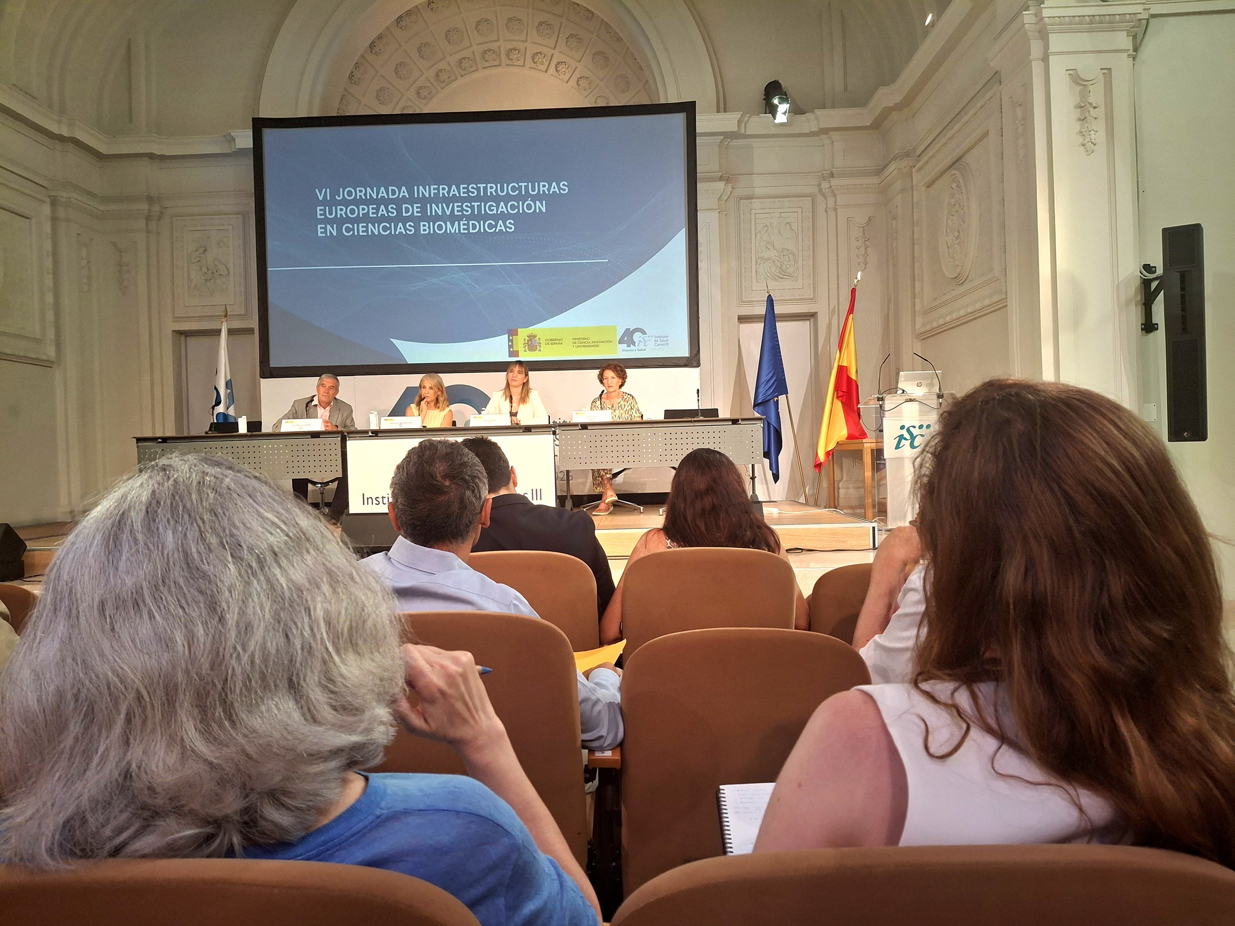 Imagen desde el público de una de las mesas redondas de la jornada, celebrada en el Salón rnest Lluch del Campus de Chamartín del ISCIII, y retransmitida desde nuestro Canal de Youtube.